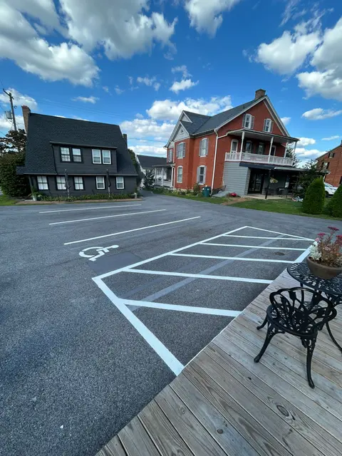 White hatched ADA access aisle and symbol on a small commercial lot