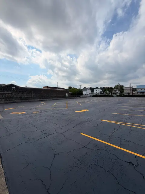 Parking lot behind a brick building with fresh yellow stall lines