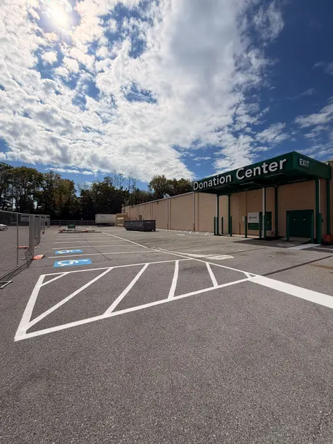 Donation center lot with blue ADA stalls and white hatched no parking area