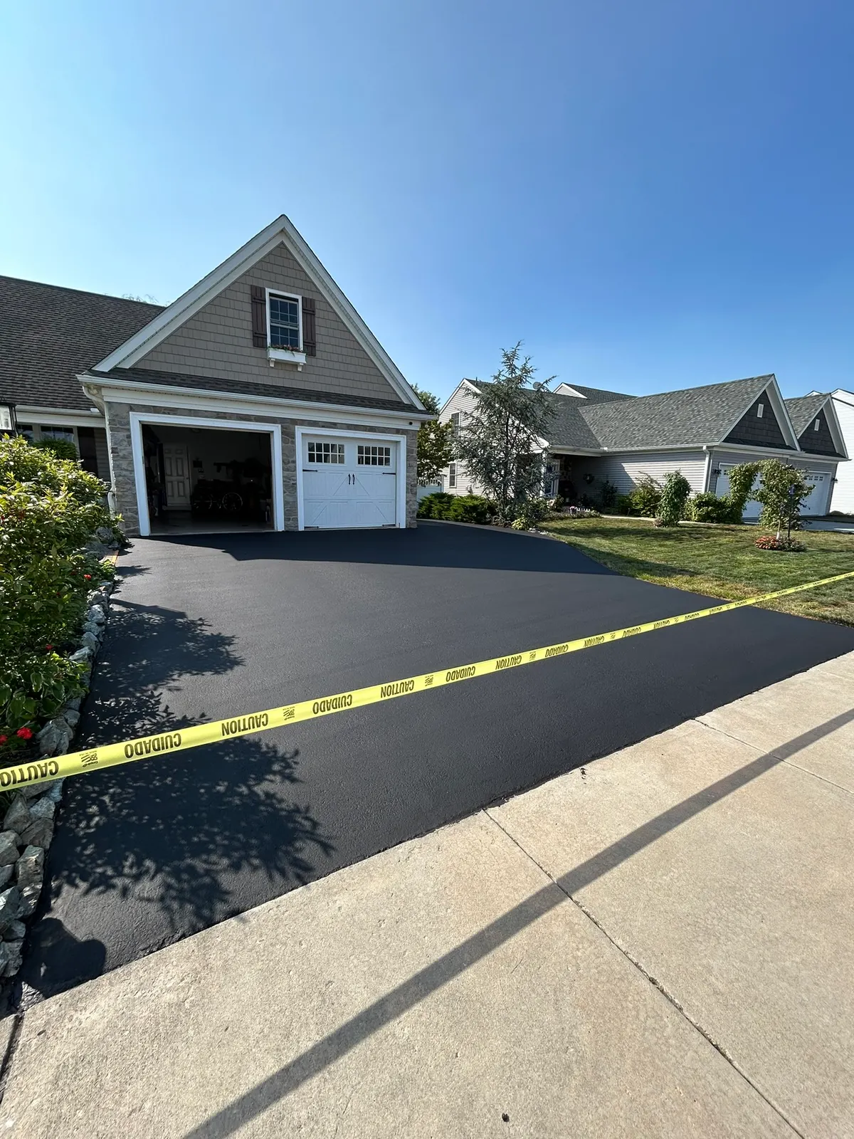 Sealcoated driveway with caution tape marking the curing zone