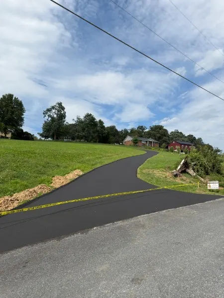 Sealcoated driveway with a clean hand-cut edge along the grass