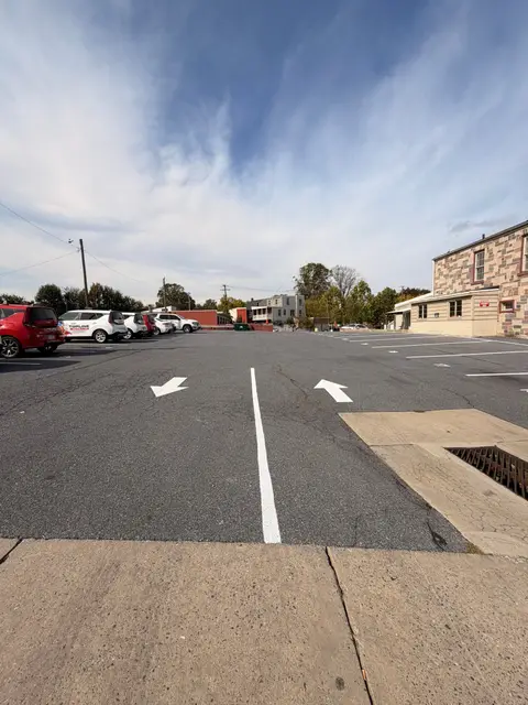 White arrows and a center line directing traffic in a parking lot