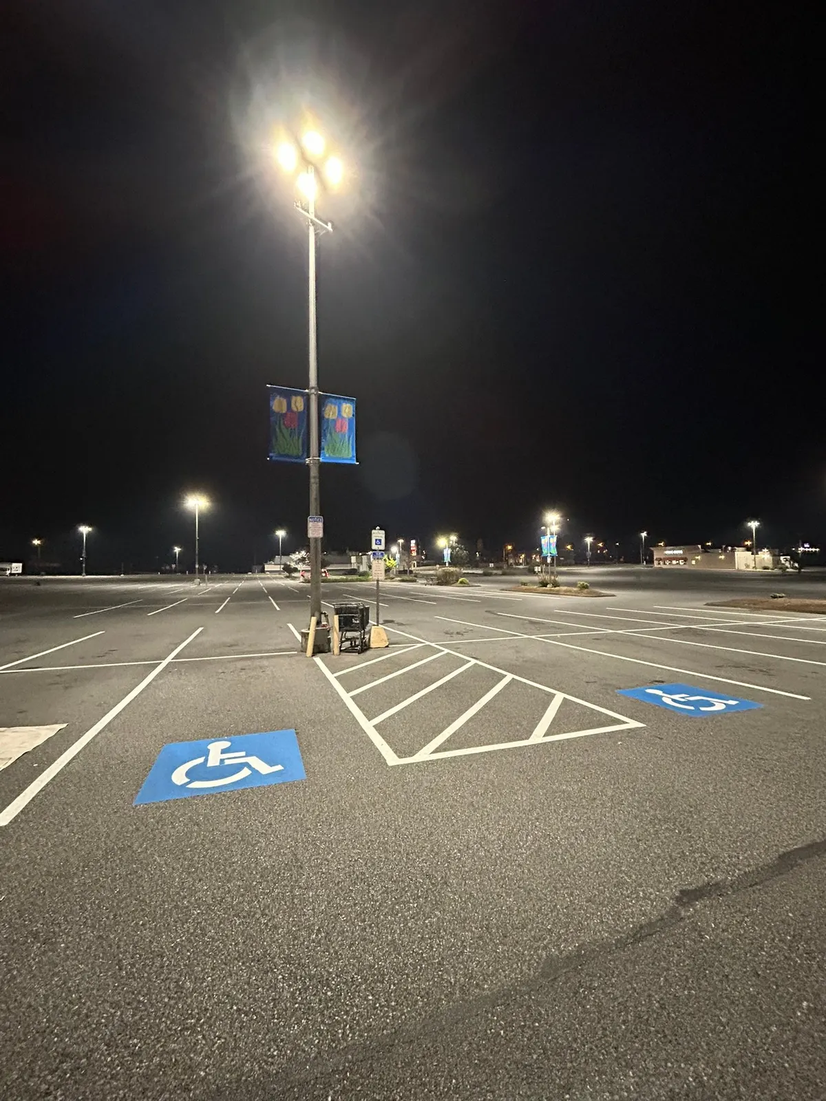 Blue ADA symbol and hatching on a lot lit by street lights