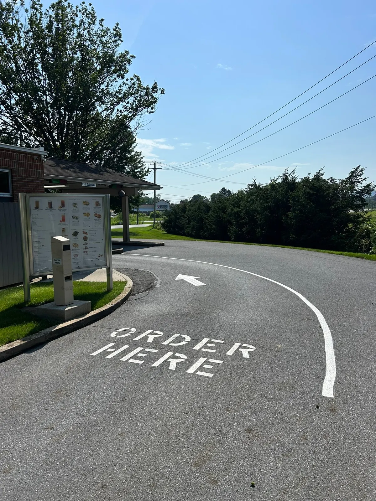 ORDER HERE stencil and curved arrow on a drive-through lane