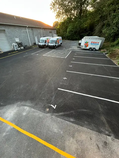 Fresh stall lines and yellow curb marking on repaired asphalt