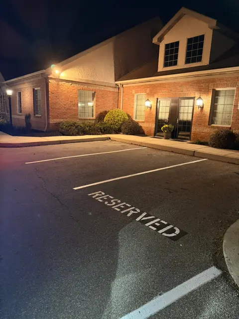 RESERVED stencil on a parking stall in front of an office at night