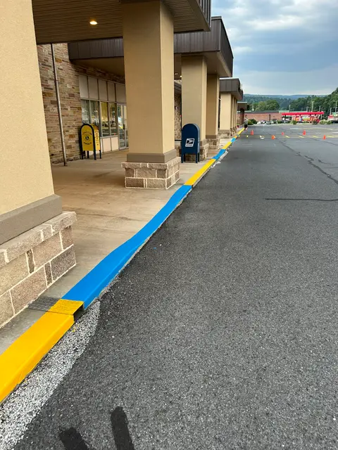 Yellow-striped parking stalls and a blue ADA curb outside a retail plaza