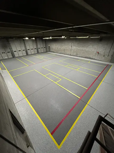 Warehouse floor with yellow lane boxes and a red divider line